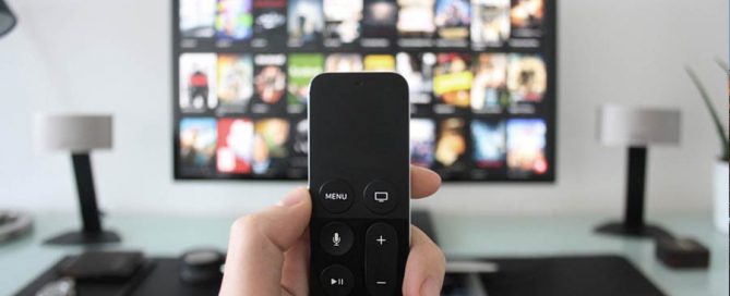 TV screen with menu choices of programs to watch with a remote control